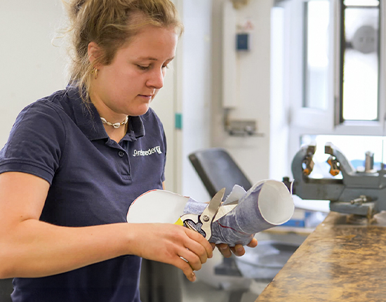 Orthopaedic technician sits in a workshop and makes an orthosis